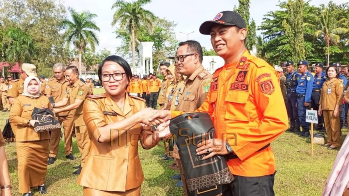 Kadis PUPR Barsel Ita Minarni menyerahkan bingkisan kepada pegawai BPBD saat apel besar usai Idul Fitri 1446 H di halaman Kantor Bupati Barito Selatan.