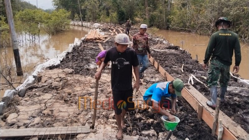 Warga Desa Talio bersama Satgas TMMD Kodim 1012/Buntok melakukan pemasangan bekisting secara manual di jalur jalan desa yang akan dicor (foto: MediaSurya.com/akhmad madani)