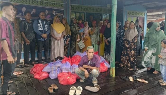 Di Tengah Hujan Deras, Rinto Rahman Tetap Bagikan Sembako ke Warga Barsel